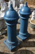 A pair of blue painted composite bollards.