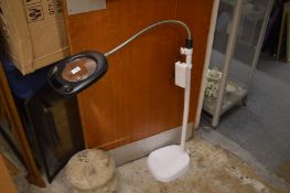 An adjustable floor standing magnifying lamp.