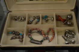 A collection of silver earrings and a decorative necklace.