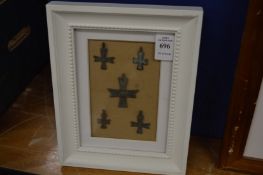 A group of bronze crosses, framed and glazed.
