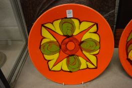 A Poole pottery dish, orange ground with stylised decoration.