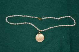 A coin pendant mounted on a pearl necklace.