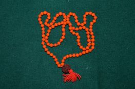 A coral coloured necklace.