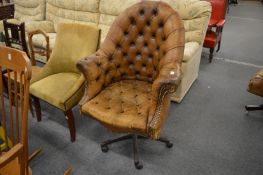 A buttoned upholstered leather office swivel armchair.
