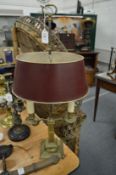 A brass twin branch table lamp with toleware shade.