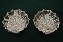 A pair of silver shell shaped dishes with pierced and embossed decoration.
