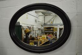 A large oval wall mirror with black painted frame.
