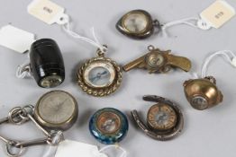 A COLLECTION OF EIGHT MINIATURE CHARM COMPASSES.