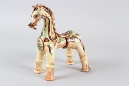 A TURKISH CANAKKALE POTTERY MODEL OF A STANDING HORSE, with brown and green glazed decoration. 22cms