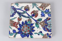 A 19TH CENTURY IZNIK POTTERY TILE, with stylised enamelled floral decoration. 22cms wide.