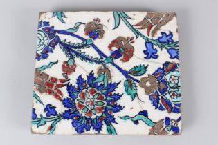 A 19TH CENTURY IZNIK POTTERY TILE, with stylised enamelled floral decoration. 22cms wide.