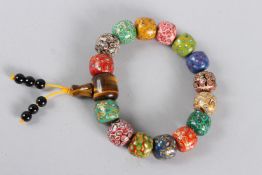 A CHINESE COLOURFUL LACQUERED BEAD BRACELET. 8cms diameter.