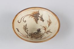 A CHINESE POTTERY CIRCULAR BOWL, painted with a bird, deer and flowers. 14cms diameter.
