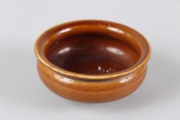 A CHINESE SMALL TREACLE GLAZED CIRCULAR PORCELAIN BOWL. 10cms diameter.