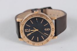 A BULGARI BRASS BLACK FACED WRISTWATCH with open back and leather strap, in case.