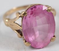A 9CT GOLD DRESS RING, set with a facet cut pink stone.