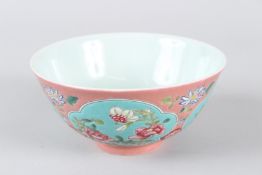 A CHINESE FAMILLE ROSE PORCELAIN BOWL, painted with panels of flowers. 15cms diameter.