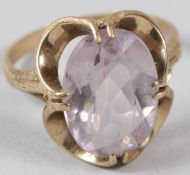 A 9CT GOLD DRESS RING, with openwork mount, set with an oval, lilac colour stone.