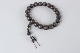 A CHINESE CARVED WOOD BEAD NECKLACE, inlaid with silver wirework decoration.