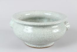 A CHINESE CELADON CRACKLE GLAZED CIRCULAR FOOTED BOWL, with moulded handles. 22cms diameter.