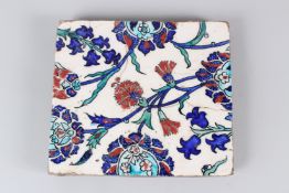A 19TH CENTURY IZNIK POTTERY TILE, with stylised enamelled floral decoration. 22cms wide.