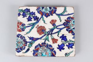 A 19TH CENTURY IZNIK POTTERY TILE, with stylised enamelled floral decoration. 22cms wide.