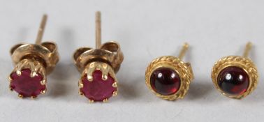 A PAIR OF YELLOW METAL AND RUBY EAR STUDS, and a pair of similar cabochon ear studs.