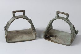 A PAIR OF 18TH - 19TH CENTURY MUGHAL INDIAN BRASS HORSE STIRRUPS. 14cms wide