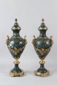 A PAIR OF 20TH CENTURY GREEN MARBLE AND ORMOLU URNS, with pineapple finials, female mask handles,