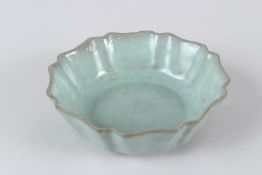 A CHINESE CELADON GLAZED PORCELAIN BRUSH WASHER, of lotus flower shape. 17cms diameter.