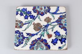 A 19TH CENTURY IZNIK POTTERY TILE, with stylised enamelled floral decoration. 22cms wide.