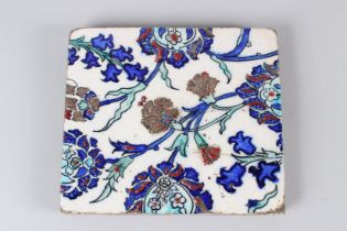 A 19TH CENTURY IZNIK POTTERY TILE, with stylised enamelled floral decoration. 22cms wide.