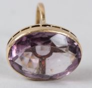 A YELLOW METAL AND AMETHYST RING, the mount set with a large oval stone, shank stamped 18K.