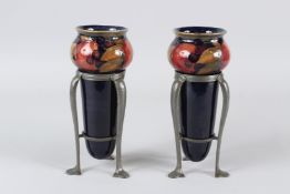 AN UNUSUAL PAIR OF MOORCROFT POMEGRANITE DECORATED AMPHORA VASES, mounted in pewter stands, probably