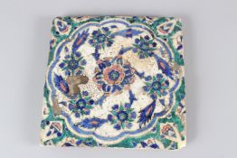 A 19TH CENTURY QAJAR POTTERY TILE, with floral decoration. 27.5cms wide.