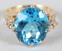 AN 18K YELLOW GOLD BLUE RING with diamond shoulders.