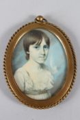 A LATE 19TH CENTURY OVAL PORTRAIT MINIATURE OF A YOUNG LADY, in a brass strut frame. 9cms x 7cms.