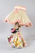 A 20TH CENTURY ITALIAN PORCELAIN FIGURAL TABLE LAMP, modelled as a young lady with floral dress.