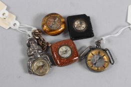 A COLLECTION OF FIVE MINIATURE CHARM COMPASSES.