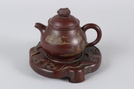 A FINE CHINESE YIXING TEAPOT with hardwood stand. 12cms high.