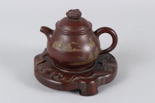 A FINE CHINESE YIXING TEAPOT with hardwood stand. 12cms high.