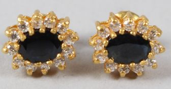 A PAIR OF YELLOW METAL, SAPPHIRE AND DIAMOND OVAL SHAPE EAR STUDS. 11mm x 8mm.