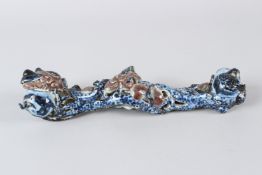A CHINESE PORCELAIN RUYI SCEPTRE, moulded design with fruit. 30cms long.