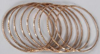 A SET OF NINE YELLOW METAL BANGLES. 55gms.