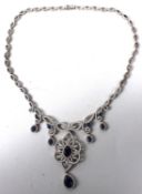 A DECORATIVE SILVER BAROQUE STYLE NECKLACE, set with clear and blue stones. 45cms long.