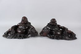 A PAIR OF 19TH / 20TH CENTURY CHINESE CARVED HARDWOOD FIGURES, depicting reclining Hotei, with a