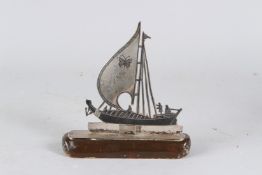 AN IRAQI NIELLO INLAID SILVER MODEL OF A BOAT. 17cms high