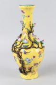 A CHINESE FAMILLE JAUNE PORCELAIN BOTTLE VASE, with moulded floral decoration. 31cms high.