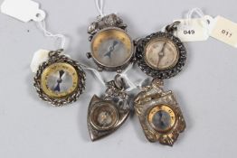 A COLLECTION OF FIVE MINIATURE CHARM COMPASSES.