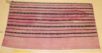 A PERSIAN SADDLE BAG, LATE 19TH CENTURY, pink ground, with striped decoration. 152cms x 84cms.